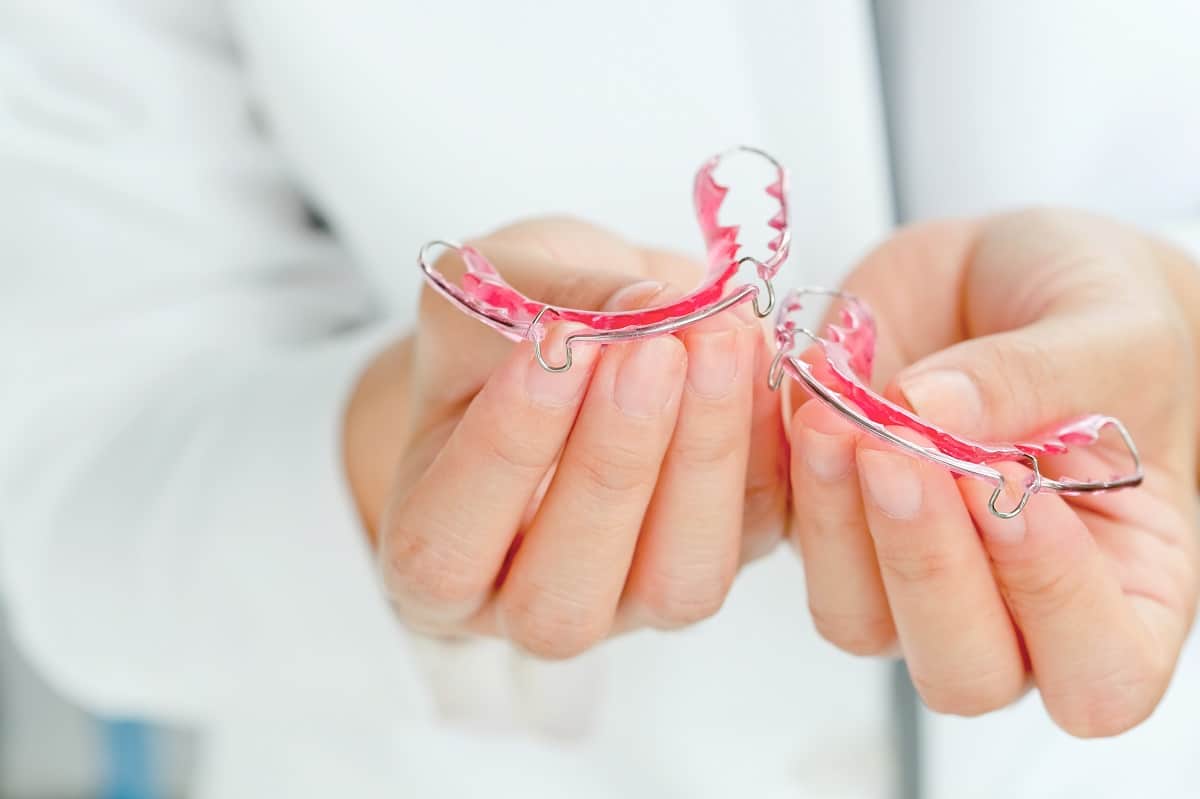 orthodontist holding invisalign in merrick