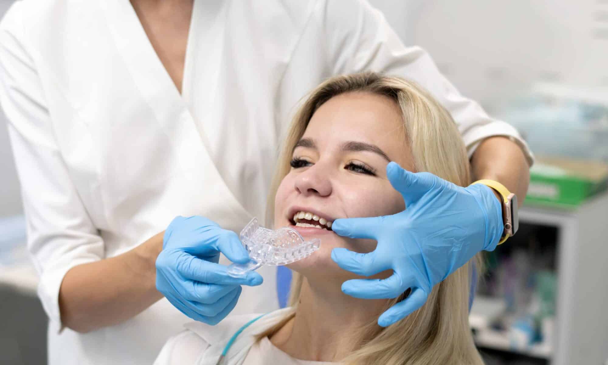 Orthodontist fitting clear aligners for a patient during an Invisalign appointment