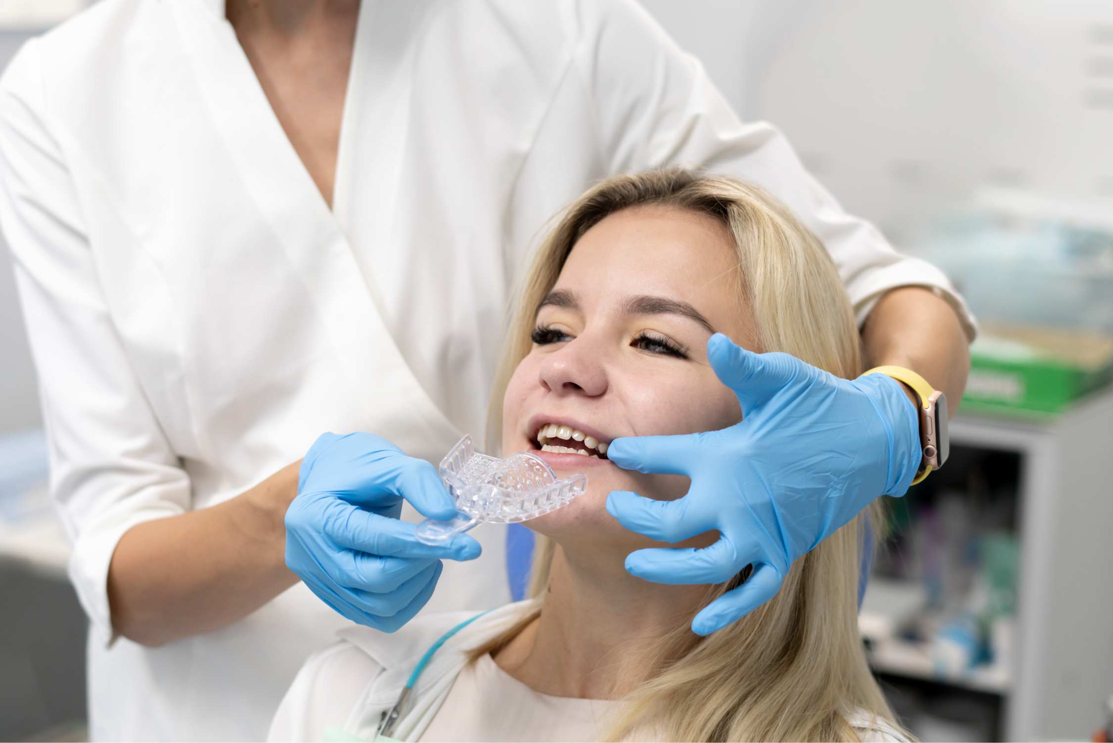 Patient Receiving Clear Aligners During an Orthodontic Visit Orthodontist fitting clear aligners for a patient during an Invisalign appointment