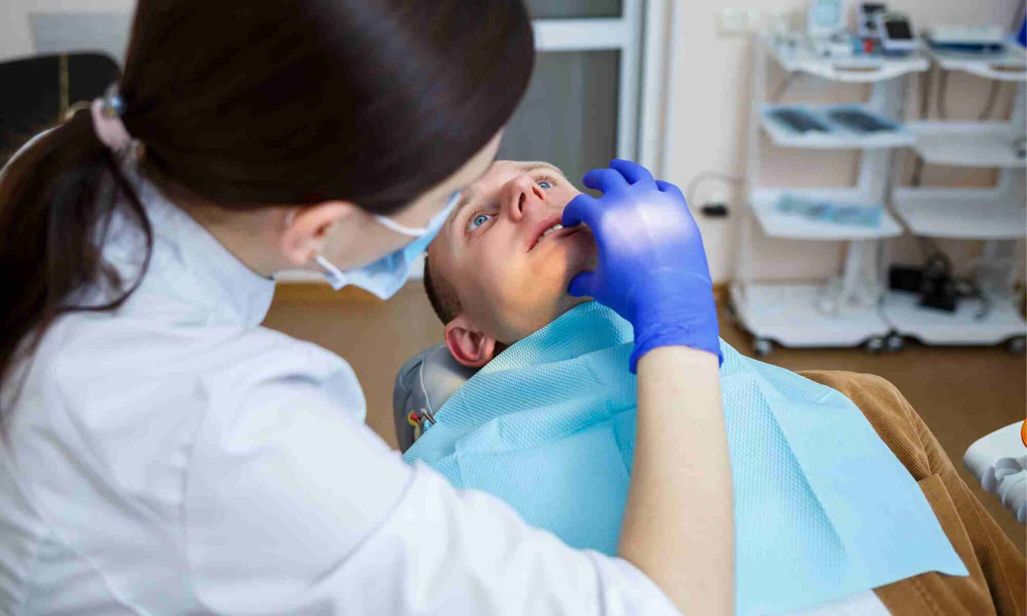 Dentist examining a patient’s teeth during an oral examination, illustrating dental evaluation of jaw and tooth alignment